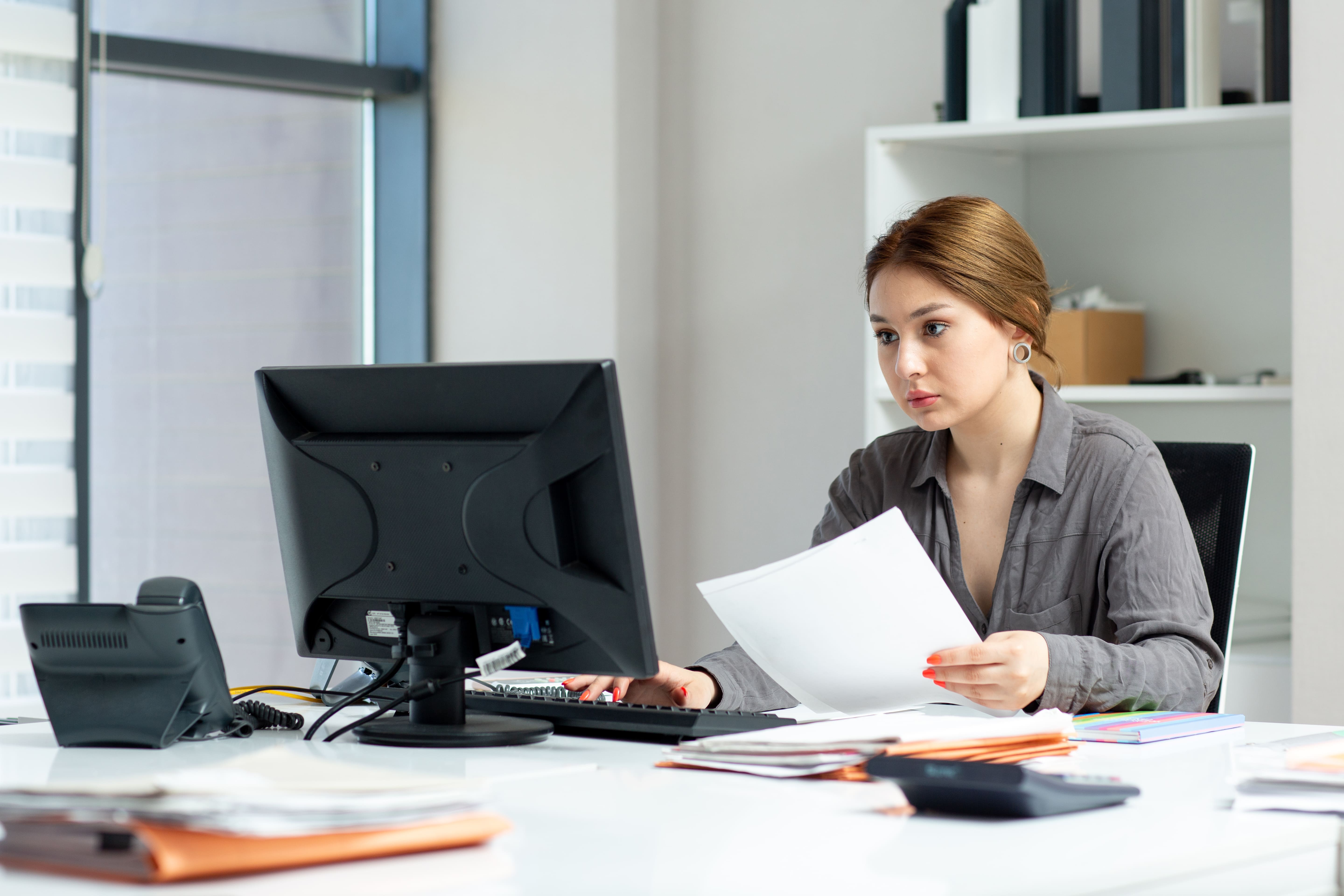 front view young beautiful lady grey shirt working her pc sitting inside her office daytime building job activity (1) (1)